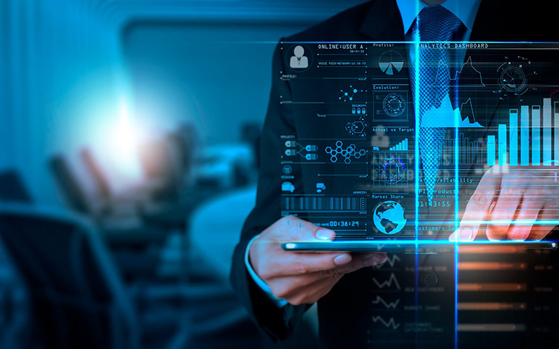 man in a suit standing behind a hologram of data analytics